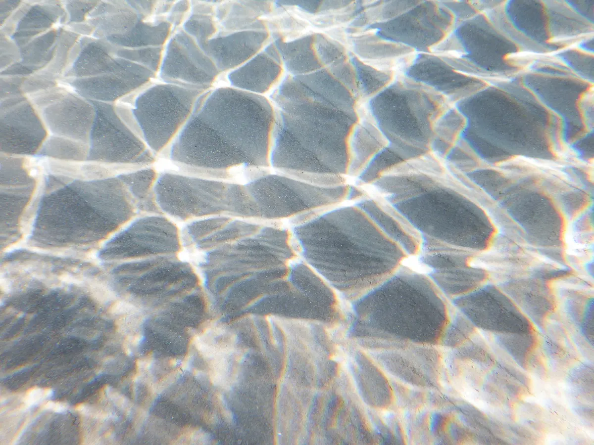 Sunlight rippling across clear, shallow water